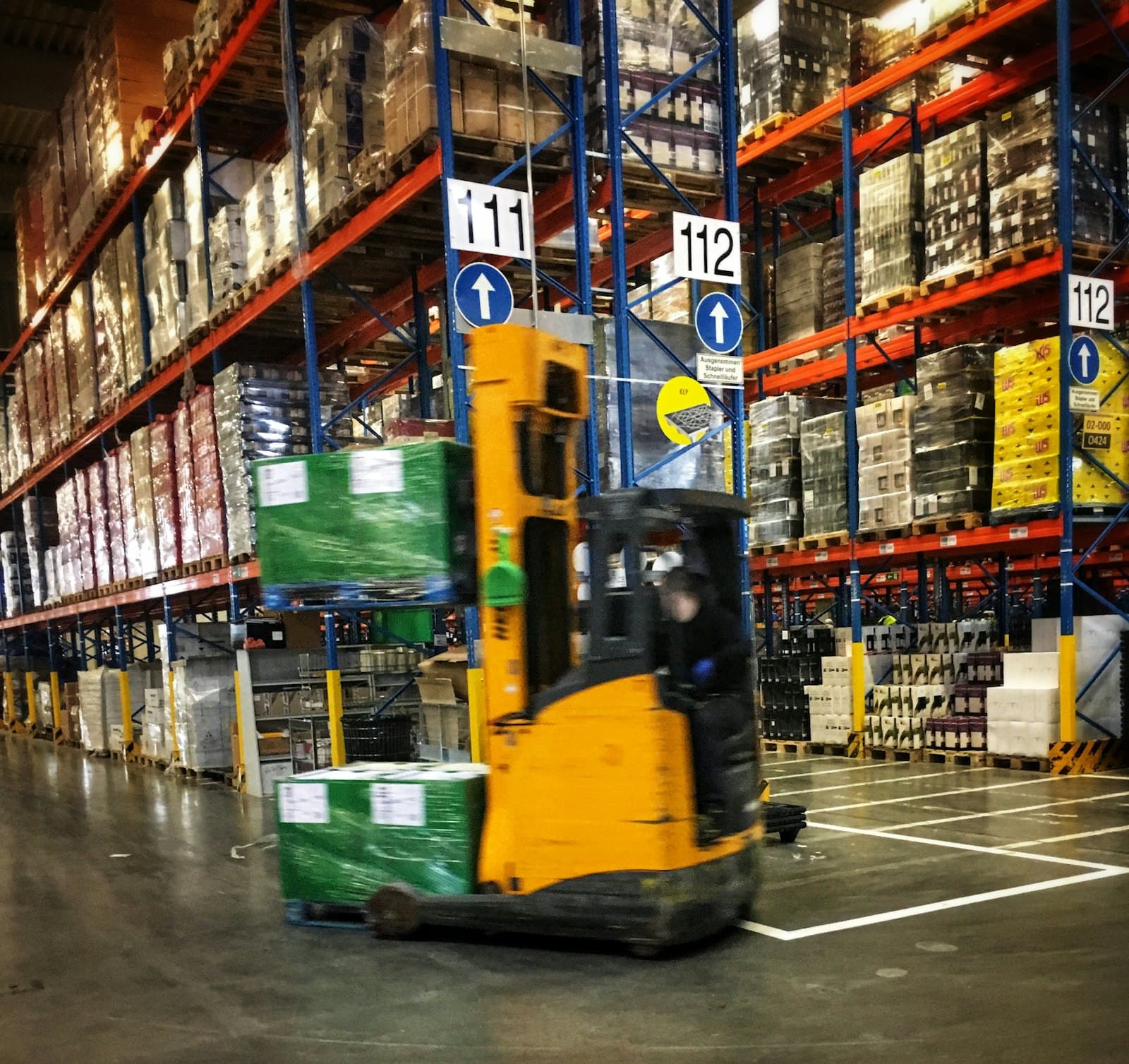 A forklift between warehouse racks